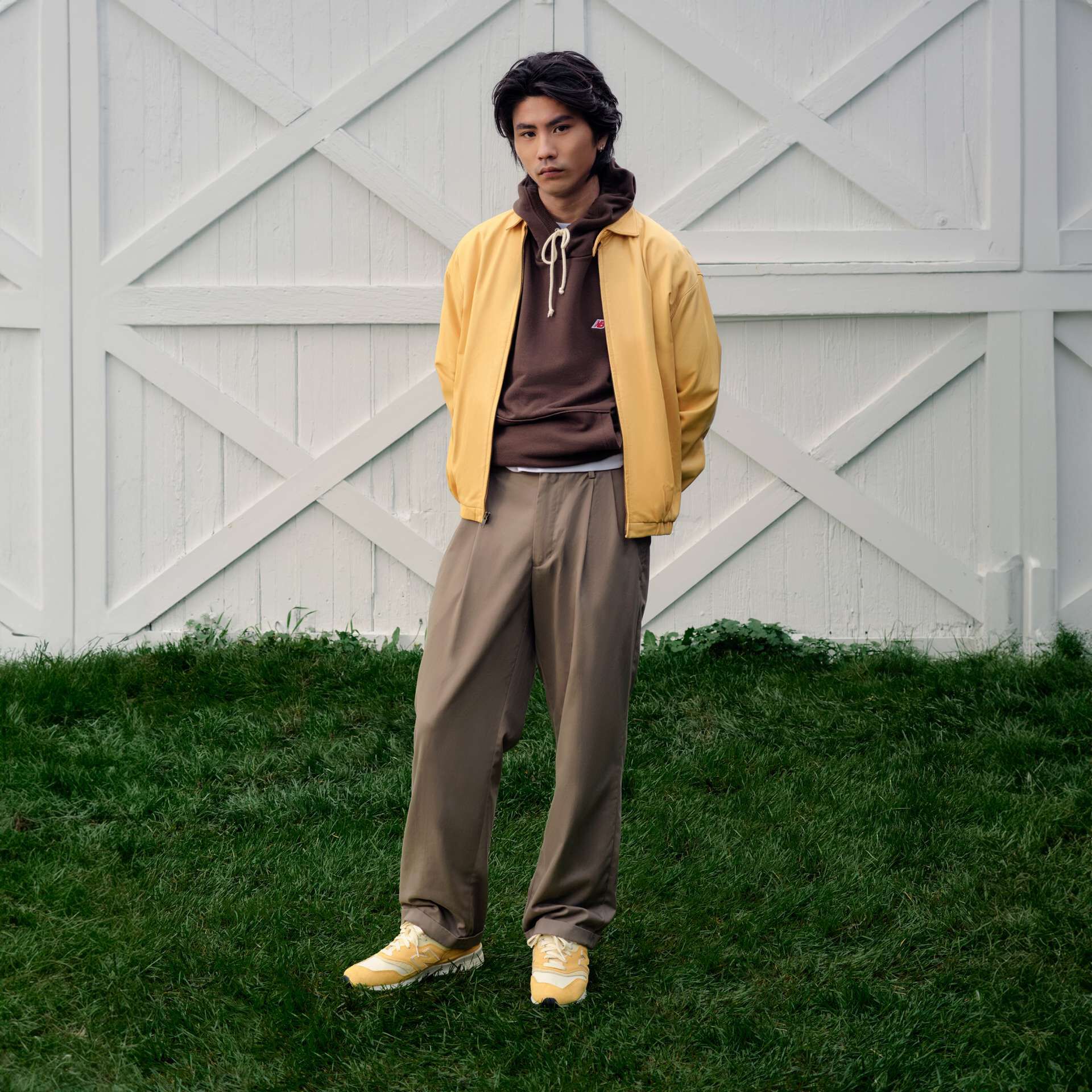 A person standing in front of white wooden barn doors.