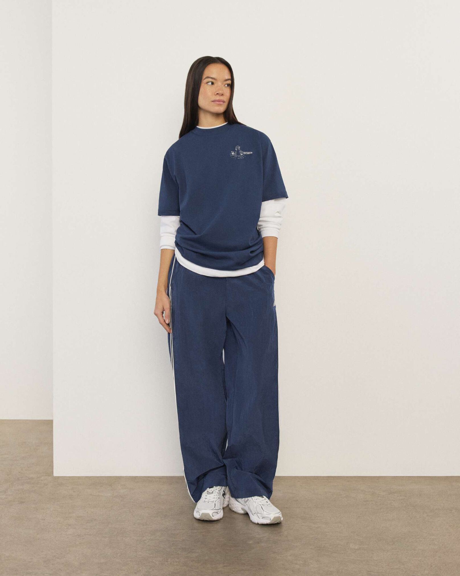 A woman standing in front a white wall.