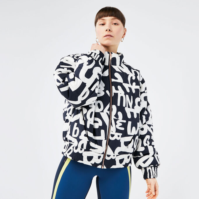 Woman posing in black and white determination jacket and determination athletic leggings.