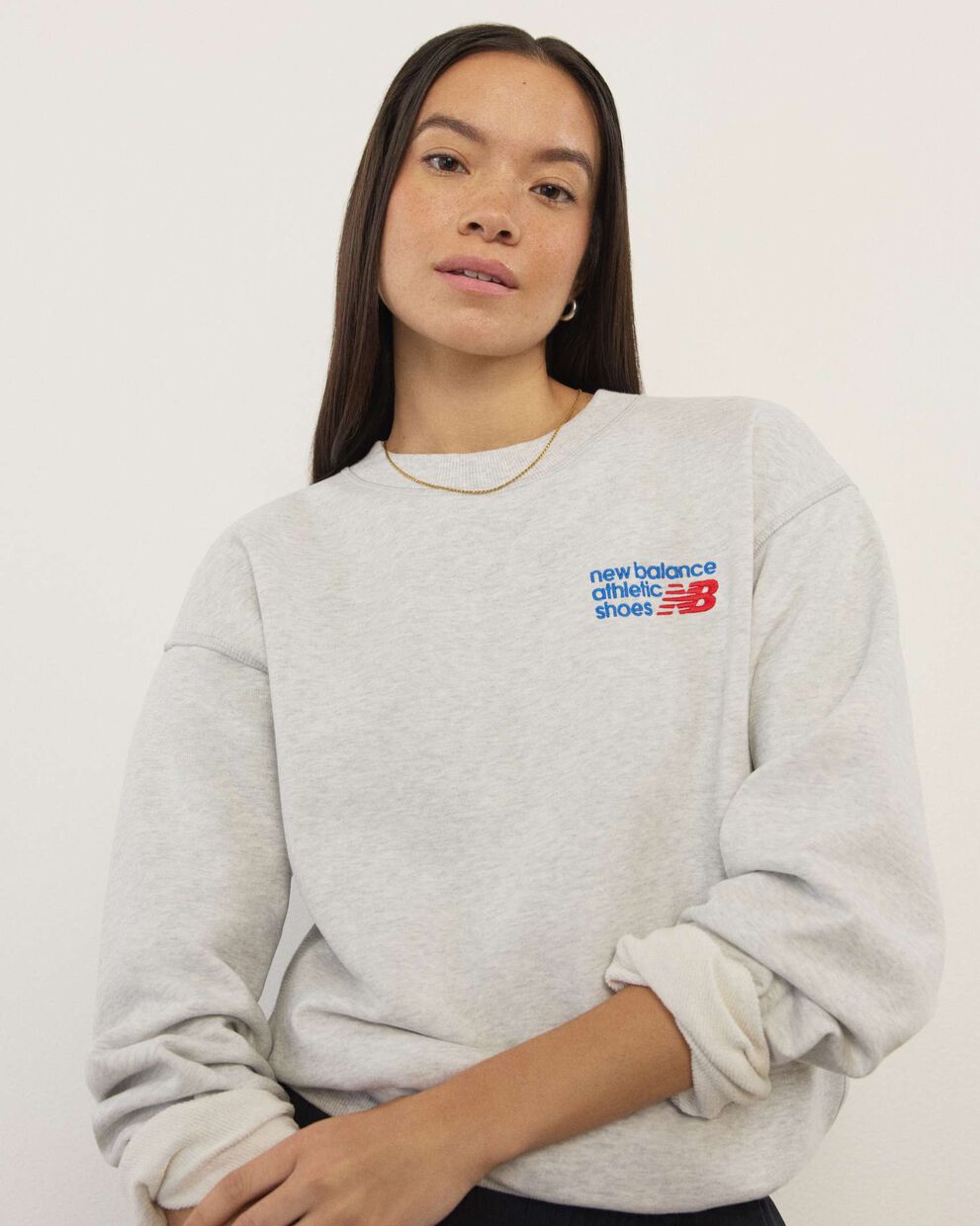 A woman standing in front a white wall.