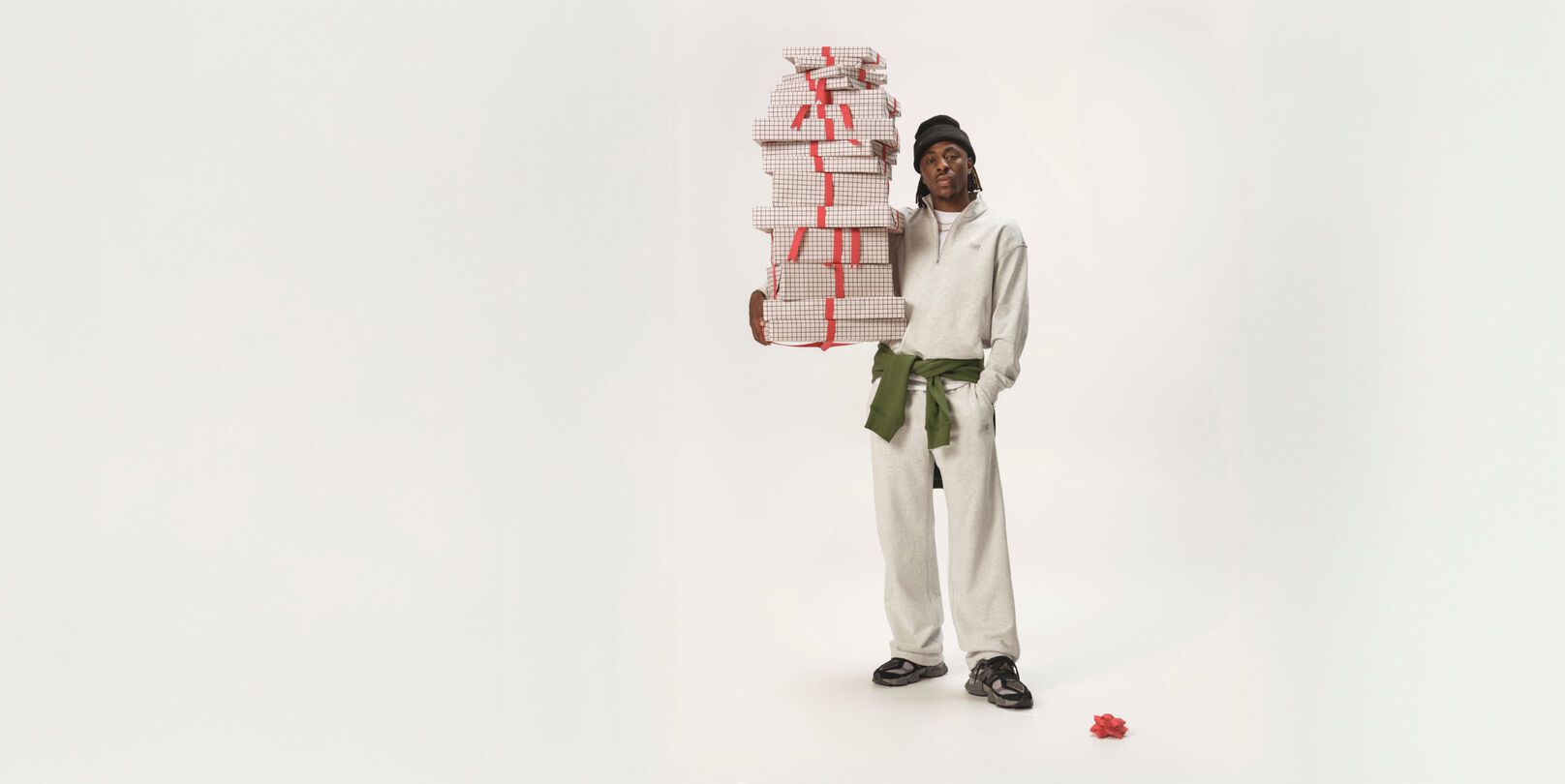 Athlète de soccer debout dans un ensemble blanc assorti, tenant des cadeaux.