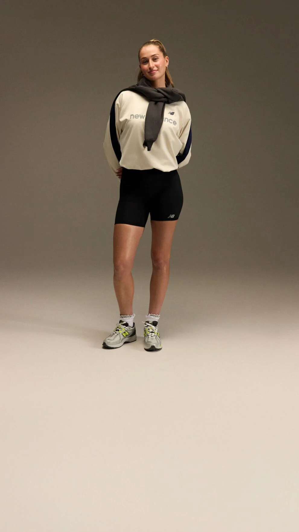 Jordyn Huitema debout avec une tenue sportive devant un fond marron et beige.