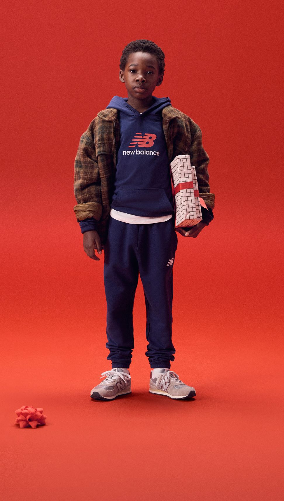 Kid holding gifts on a red background. 