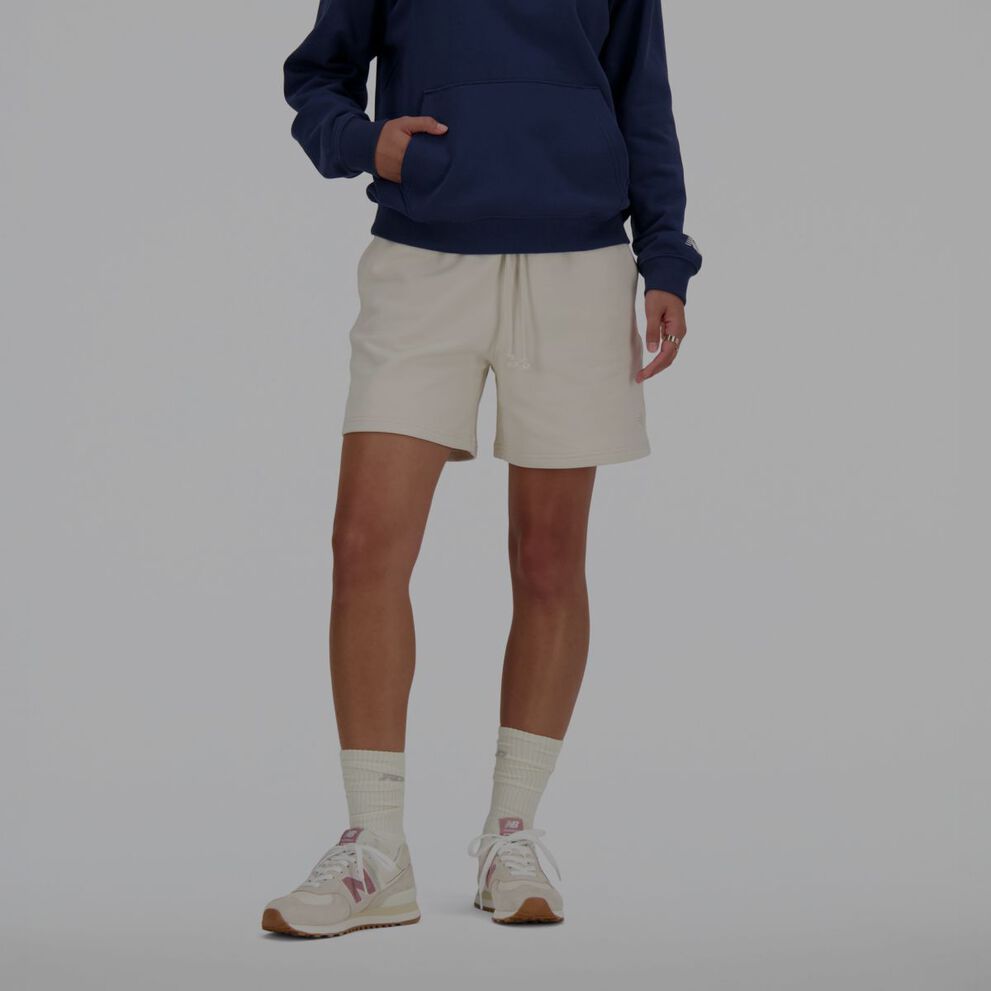 Person wearing white New Balance shorts.