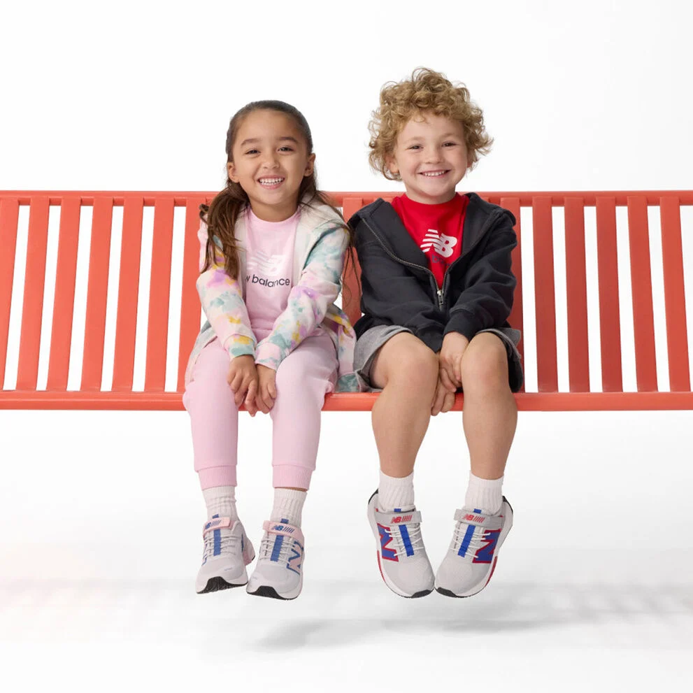 Garçon et fille assis sur un banc rouge
