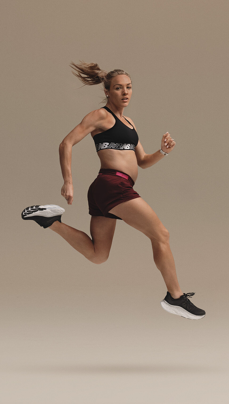 Femme enceinte dans une pose de course en plein air portant une tenue de course NB 