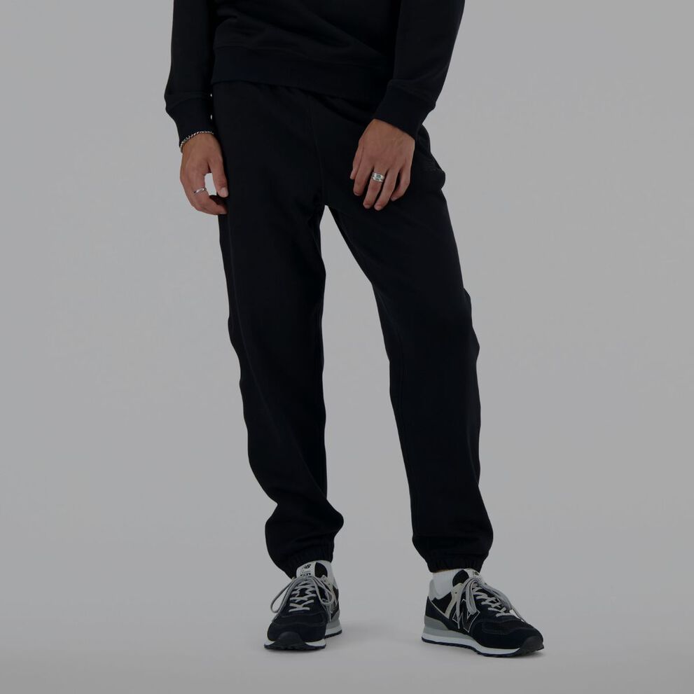Un homme portant un pantalon de survêtement noir New Balance.