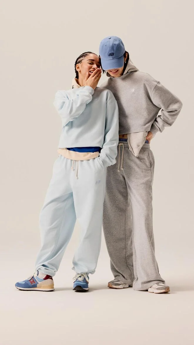 A couple wearing light blue and grey sweats while talking to each other. 