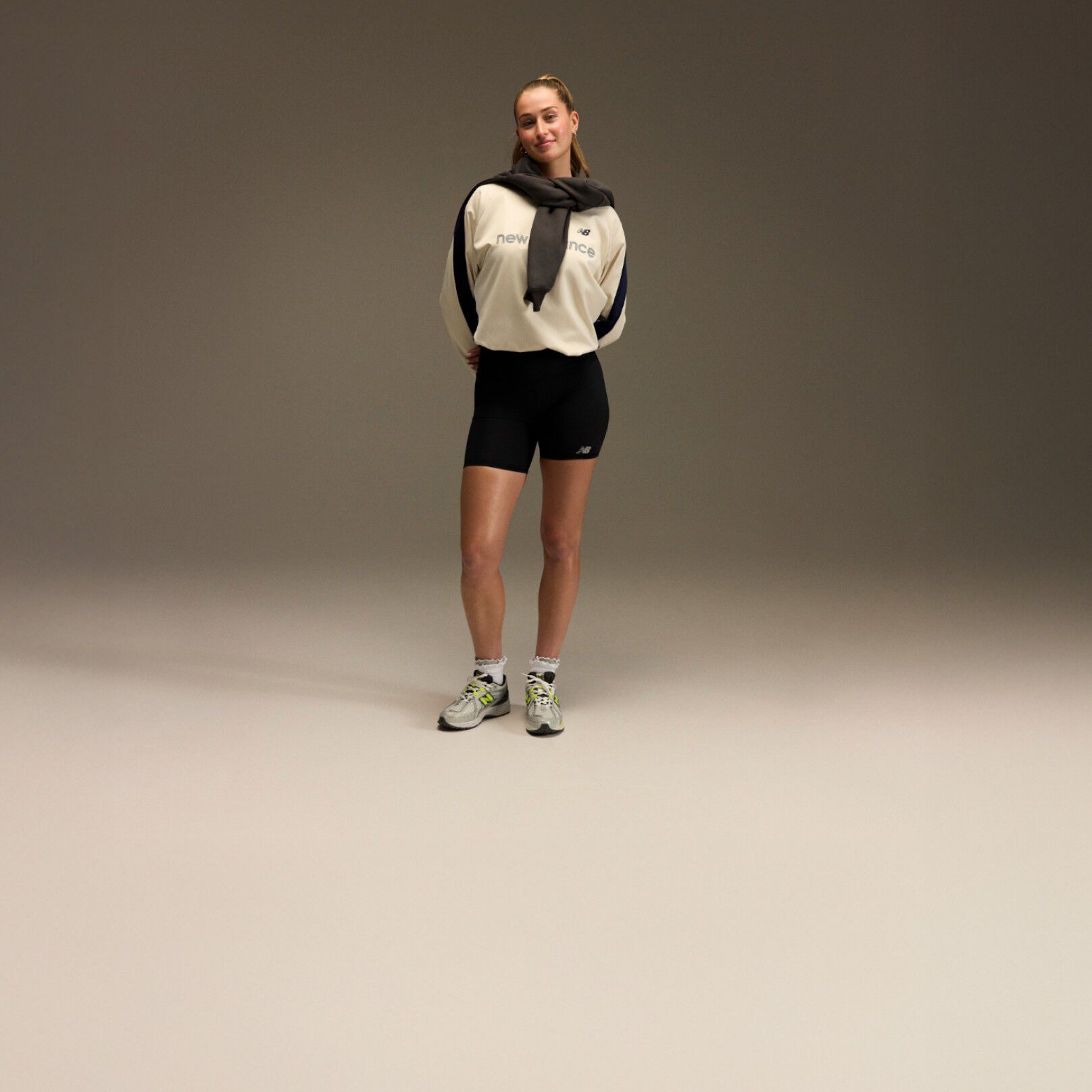 Jordyn Huitema standing with an athletic outfit in front of a brown and tan background.