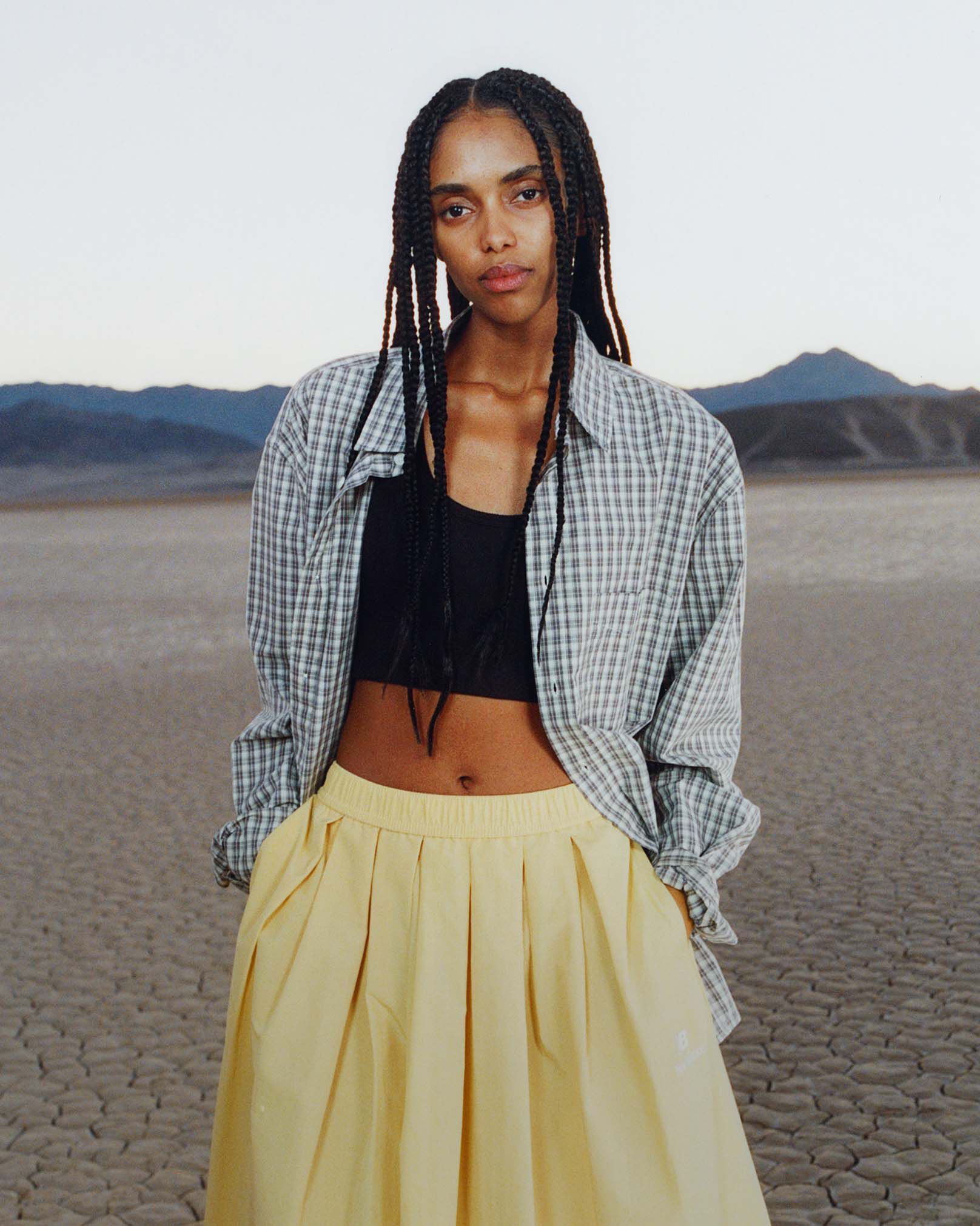 Une femme debout dans un environnement d&eacute;sertique.