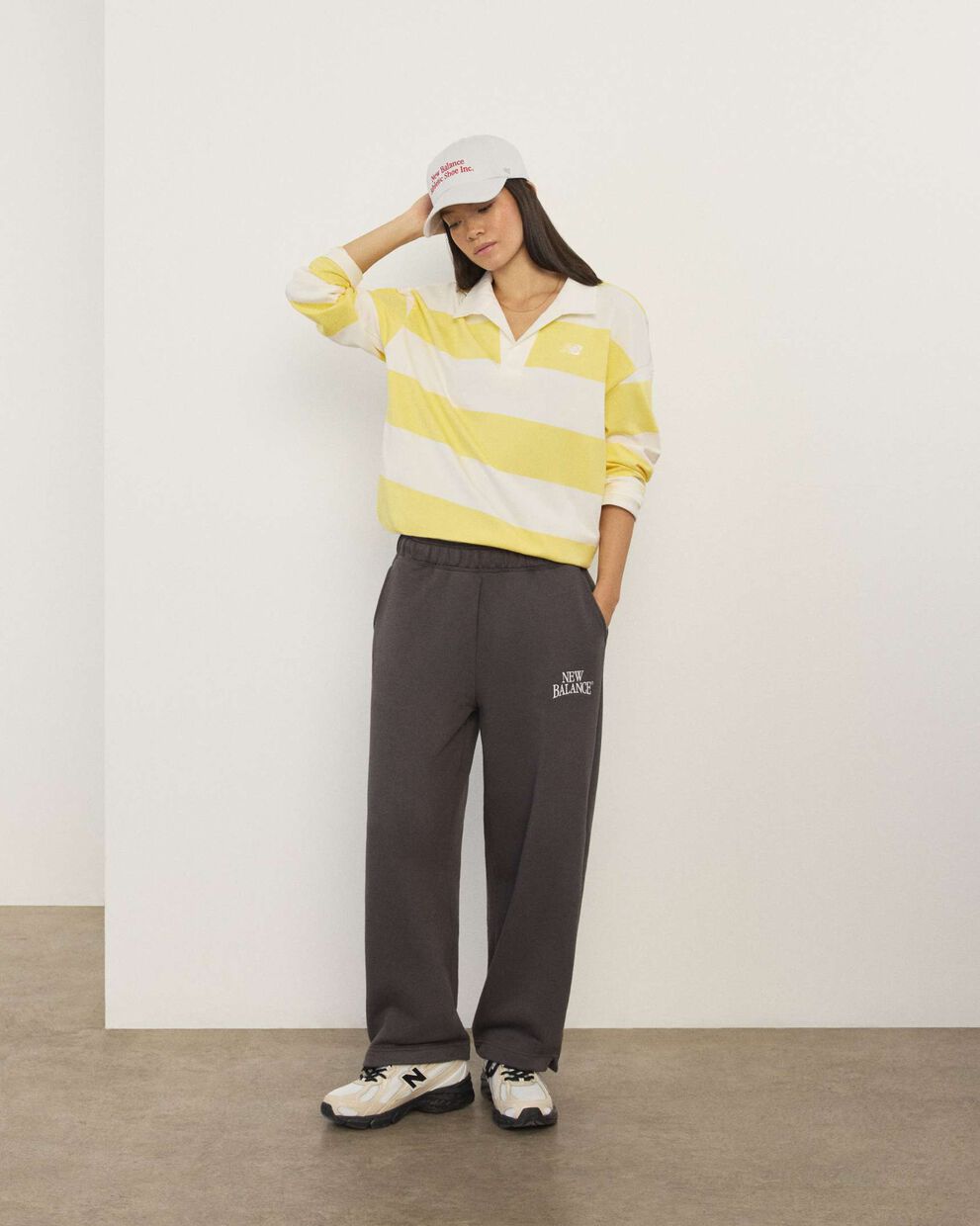 A woman standing in front a white wall.