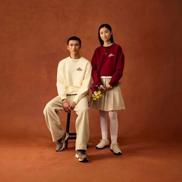 Man sitting on a stool and woman standing up.