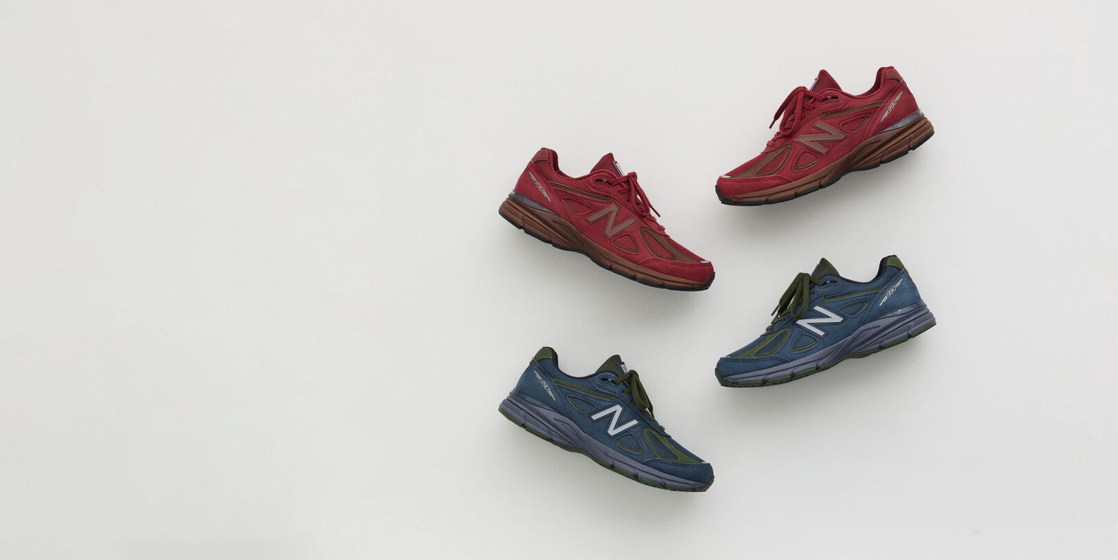 A maroon and navy shoe laying on a grey studio backdrop.