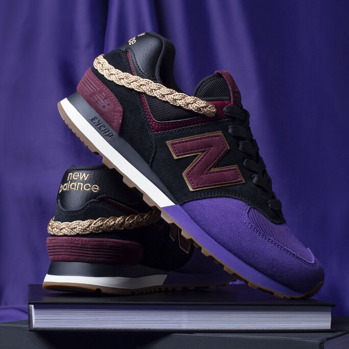 Black History Month exclusive 574 pair sitting on black books with velvet background.