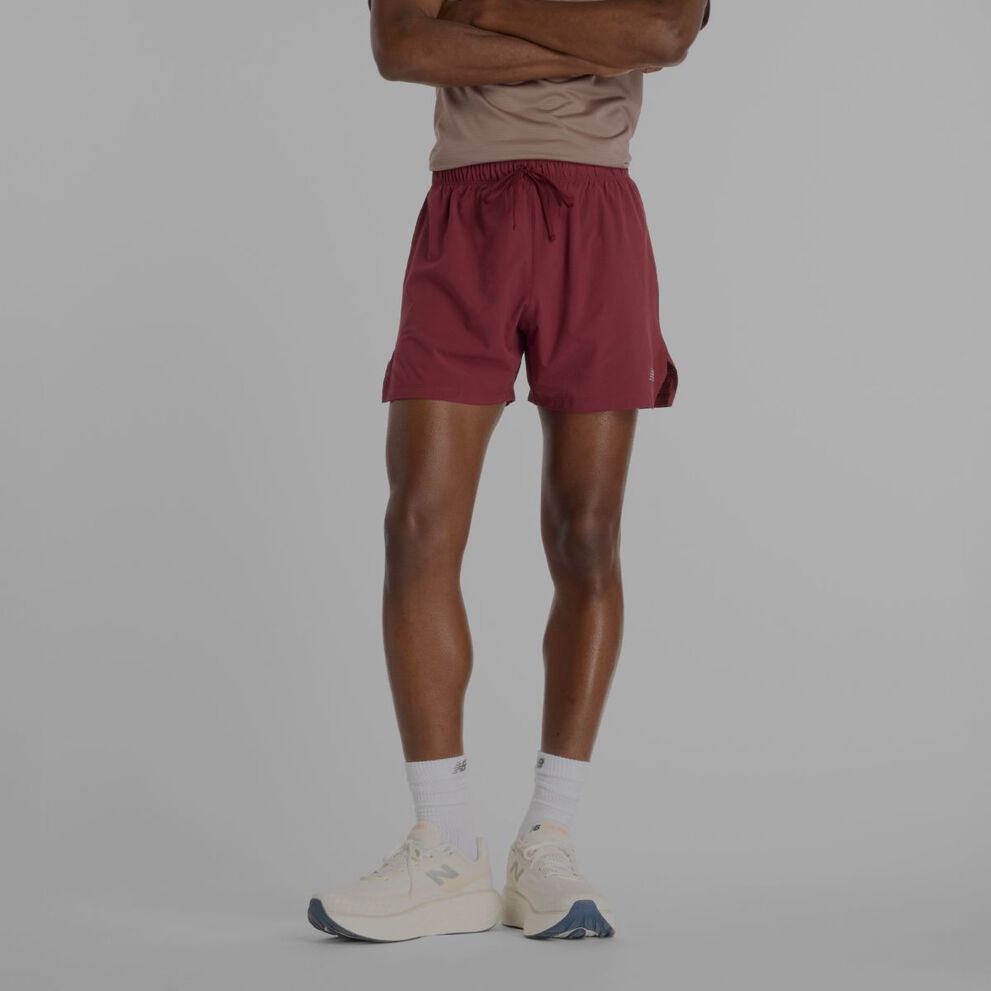 Personne portant un short New Balance rouge.