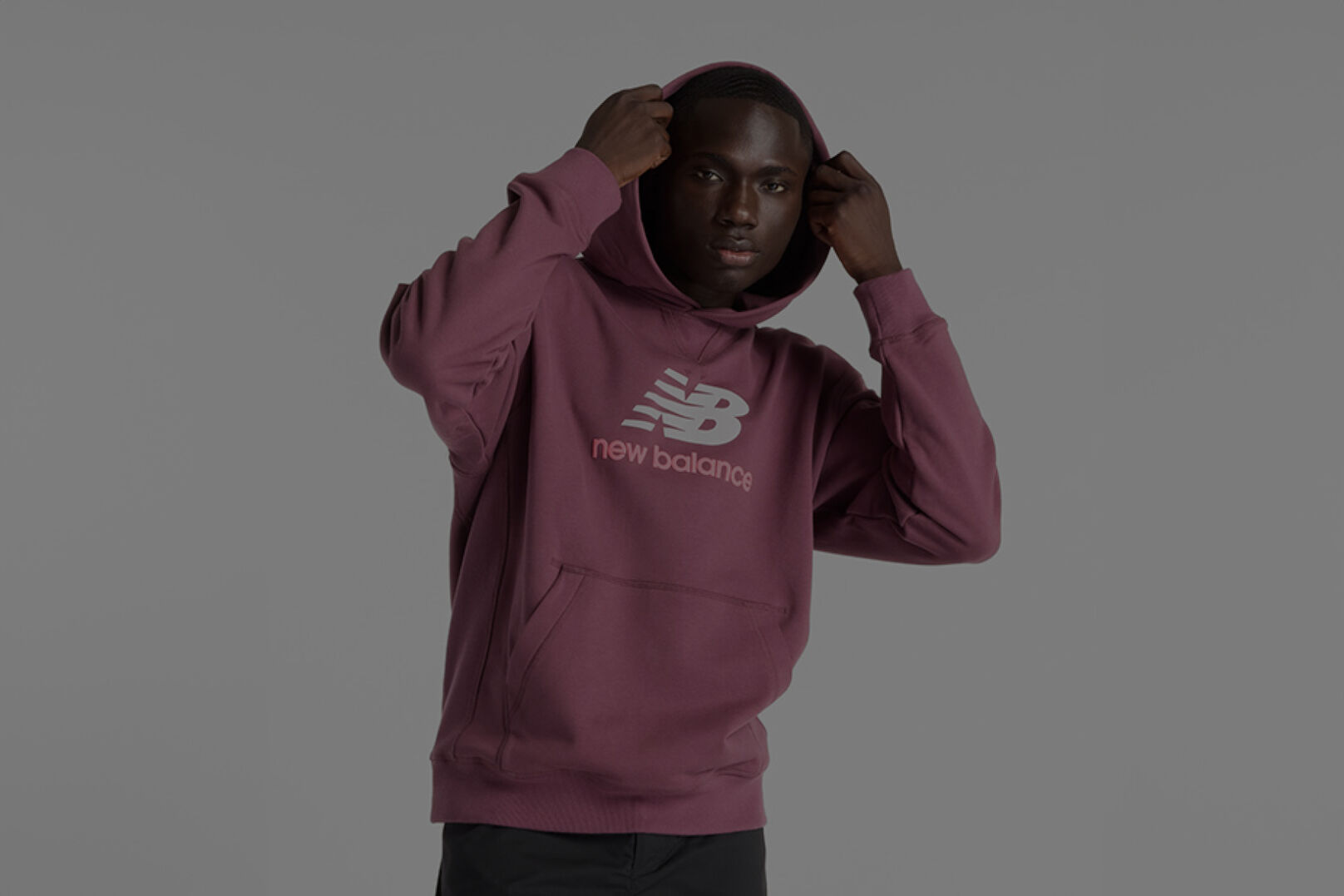 Homme portant un chandail New Balance marron.