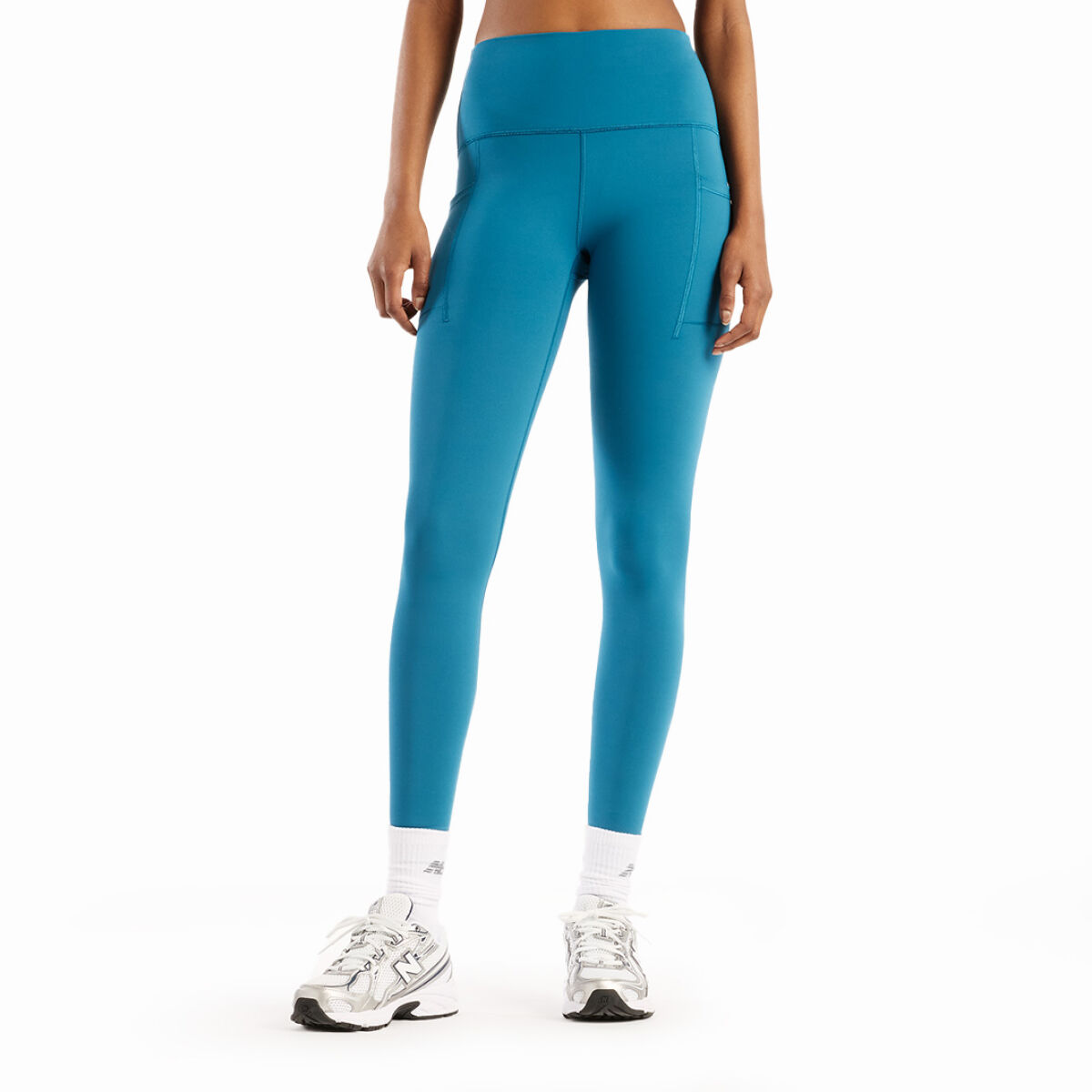 Close-up of blue running leggings with a utility belt paired with bright green running shoes on a white background. 