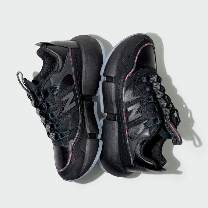 Dépôt aérien de chaussures Vision Racer noires sur fond gris de studio.
