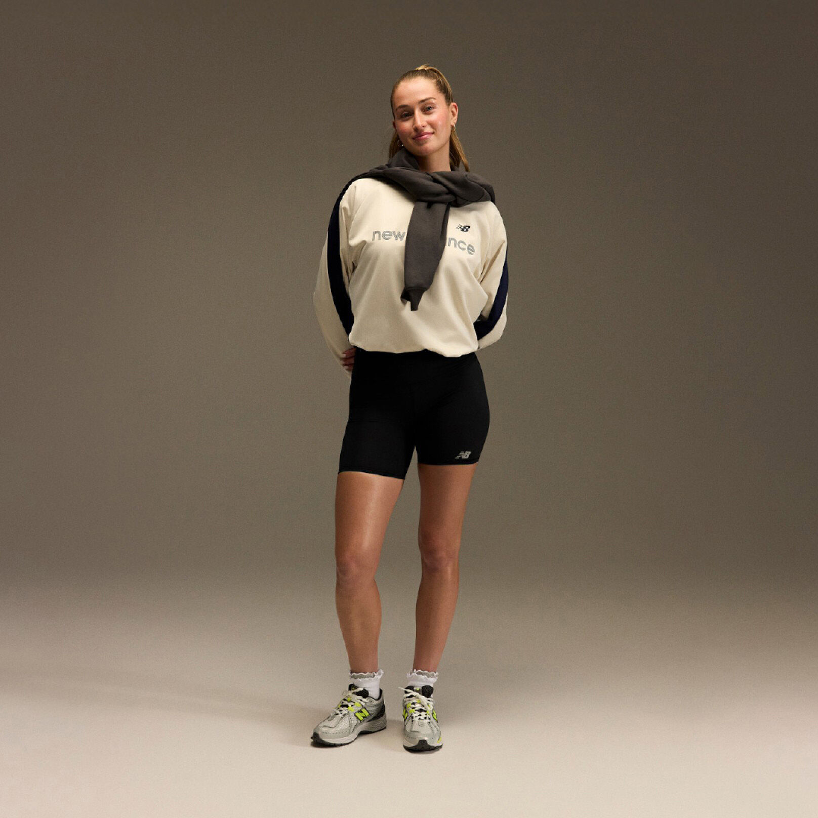 Jordyn Huitema standing with an athletic outfit in front of a brown and tan background.