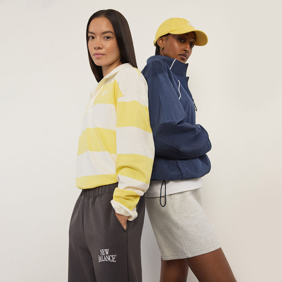 Deux femmes debout devant un mur blanc.