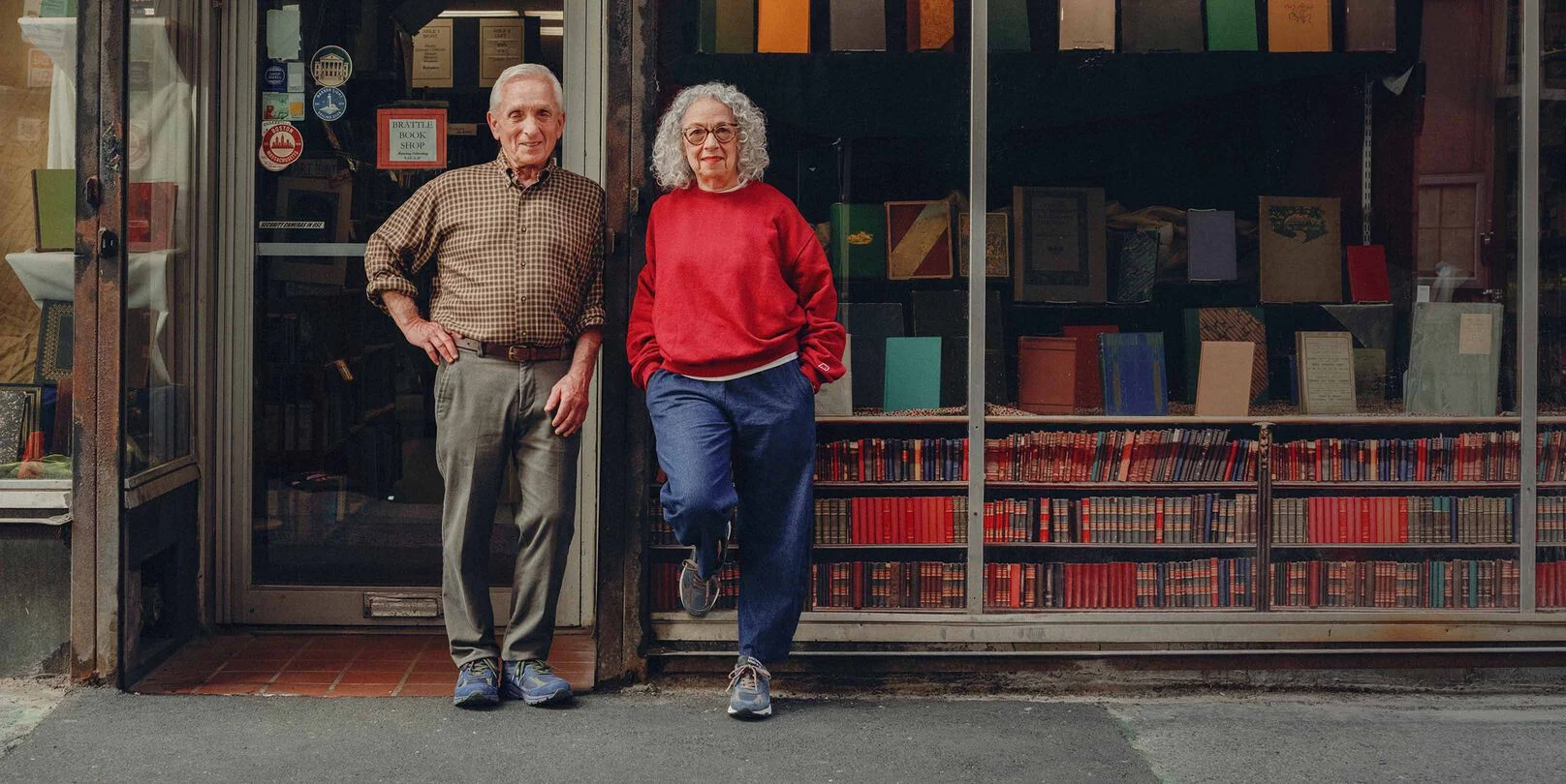 Un homme et une femme debout dans la rue devant une librairie.