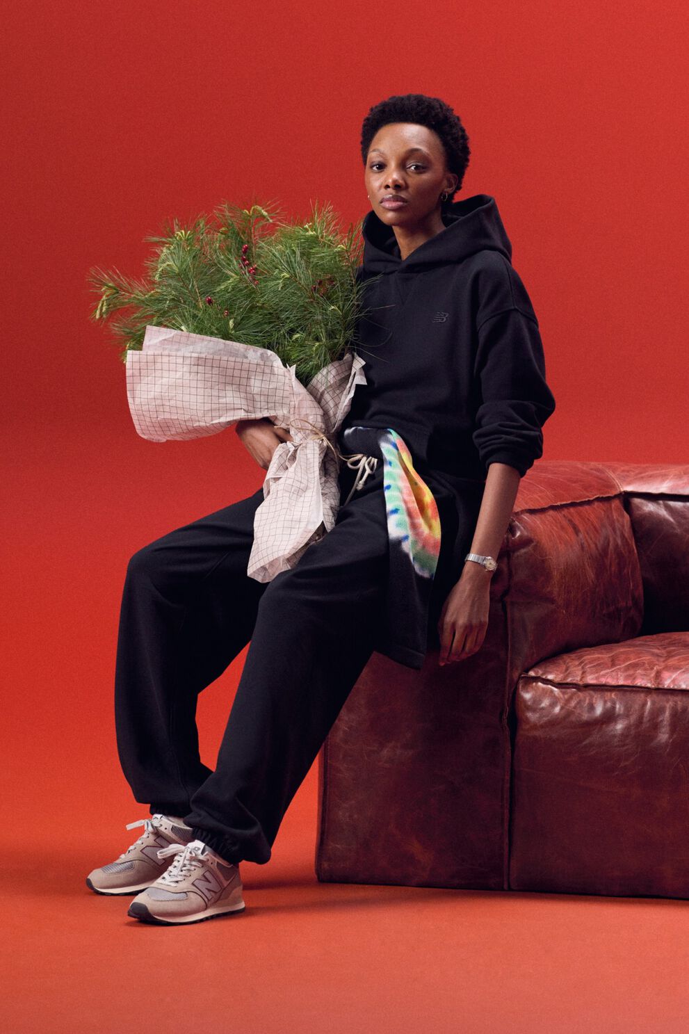 Jeune femme vêtue d’une tenue noire tenant un sac de guirlandes.