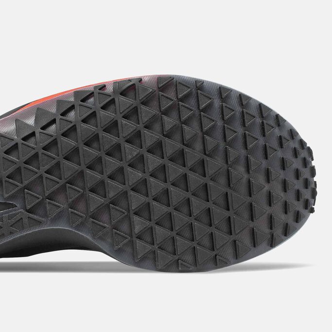 Vue du dessous de la semelle d'usure à motifs en triangle dont est dotée la chaussure de course noire FuelCell Speedrift