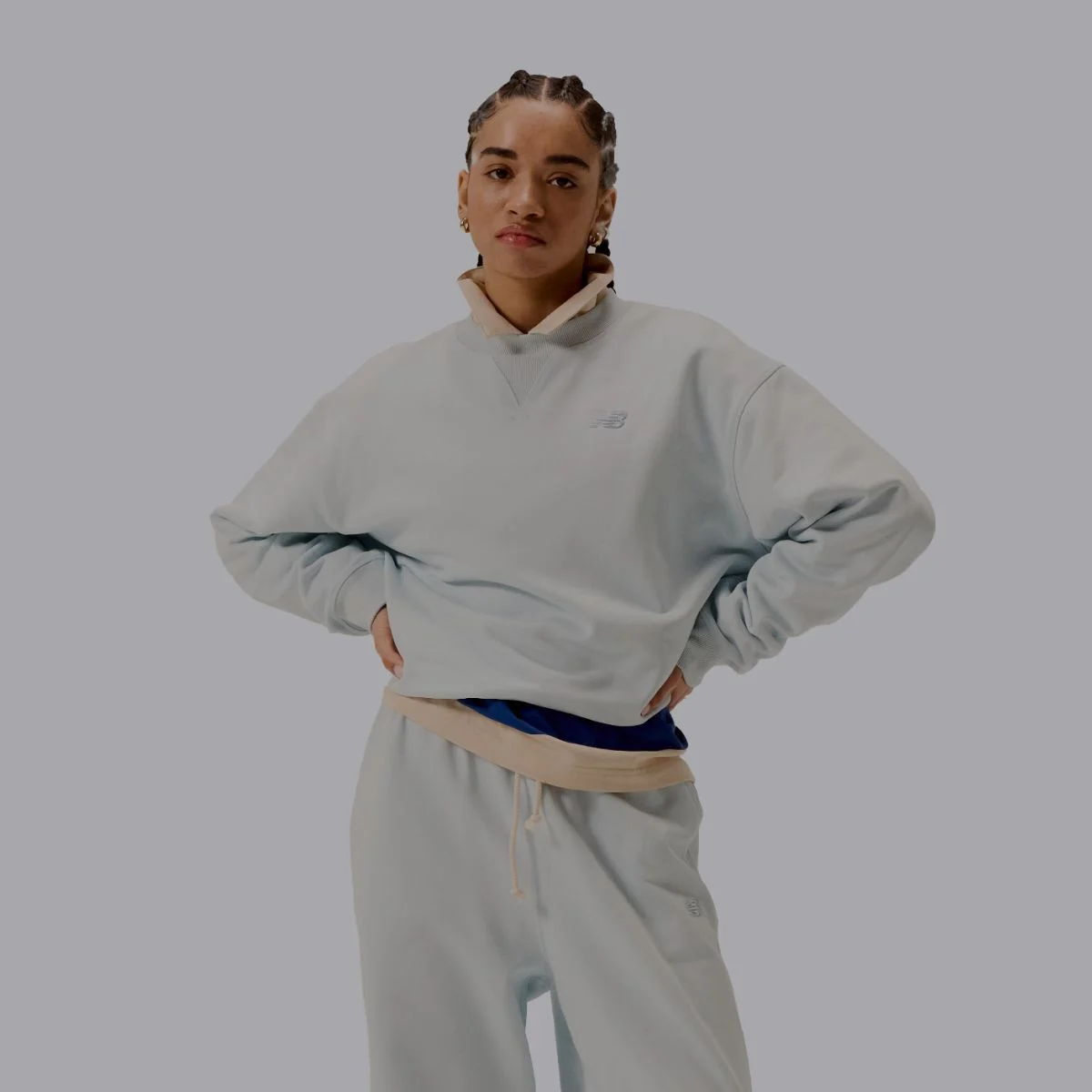 Une femme portant un ensemble assorti gris de vêtements New Balance.