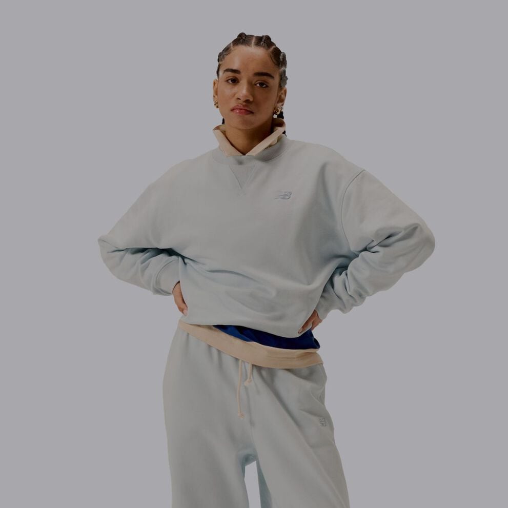 Une femme portant un ensemble assorti gris de vêtements New Balance.