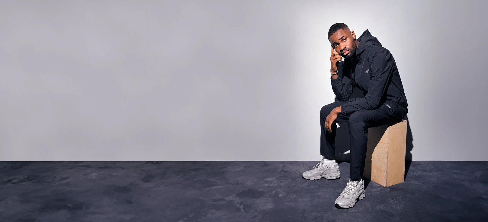 Un modèle, assis, arborant les chaussures M1000TE. 