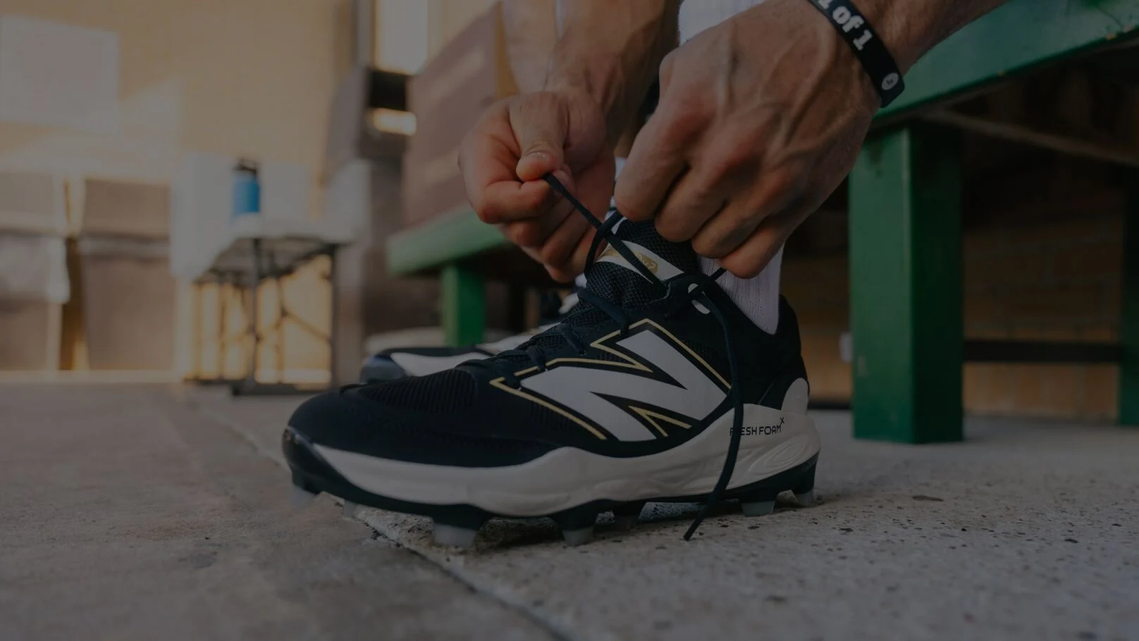 Athlète de baseball attachant ses crampons dans un abri.