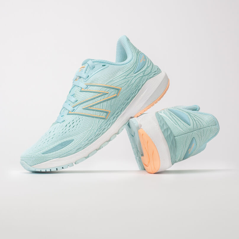Vue de côté de la chaussure gauche Fresh Foam X 860v12 de couleur bleue claire posée contre le talon de la chaussure droite, le talon étant orienté vers l'avant