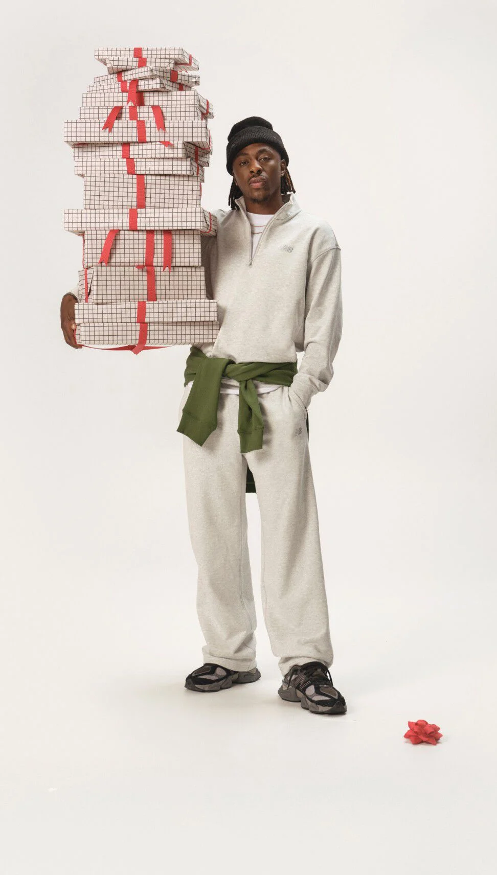 Soccer athlete Eze holding gifts on a grey background.