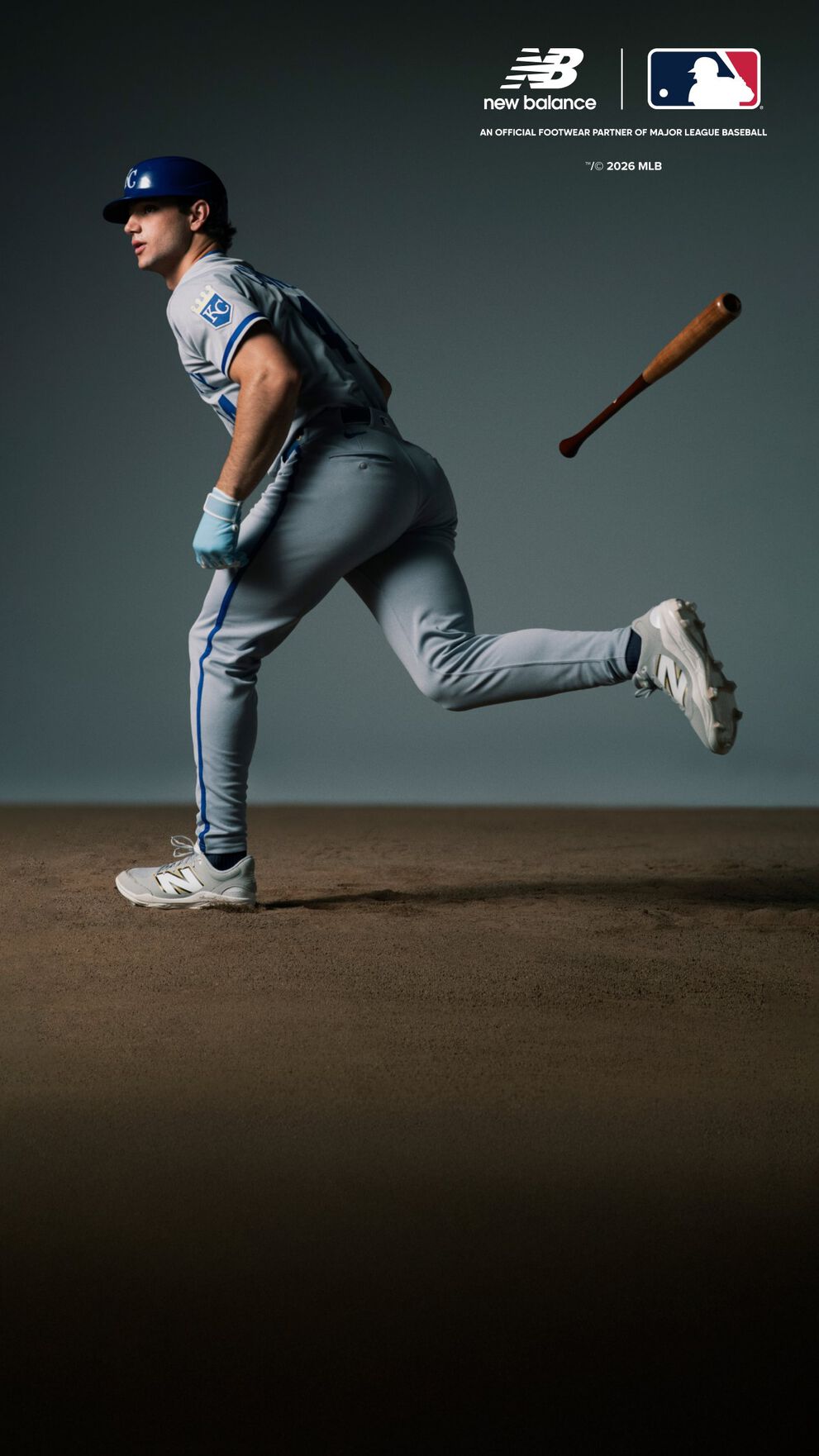 A baseball player wearing a light blue uniform with white and blue accents is running forward after swinging a bat, which is seen mid-air behind the player.