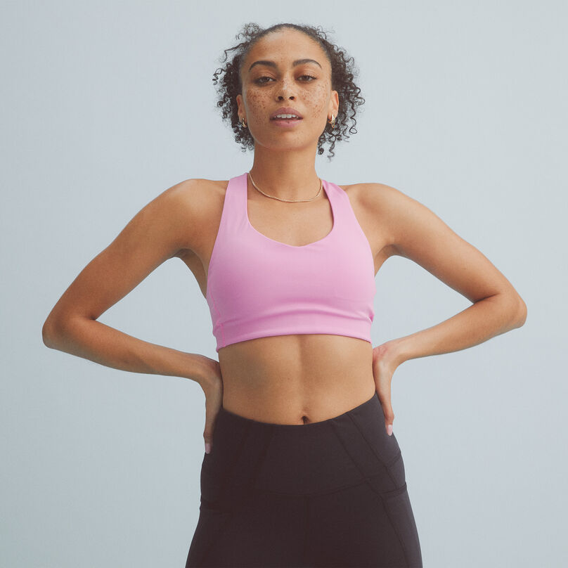 Woman wearing a pink NB Fuel Bra with black leggings