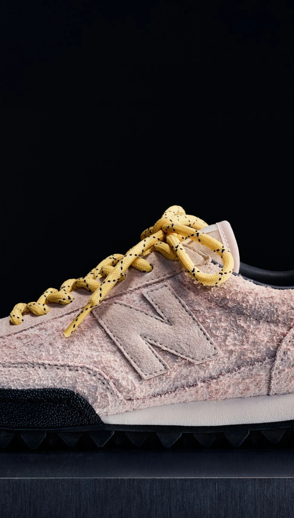 A pink suede Gator Run shoe on a black background.