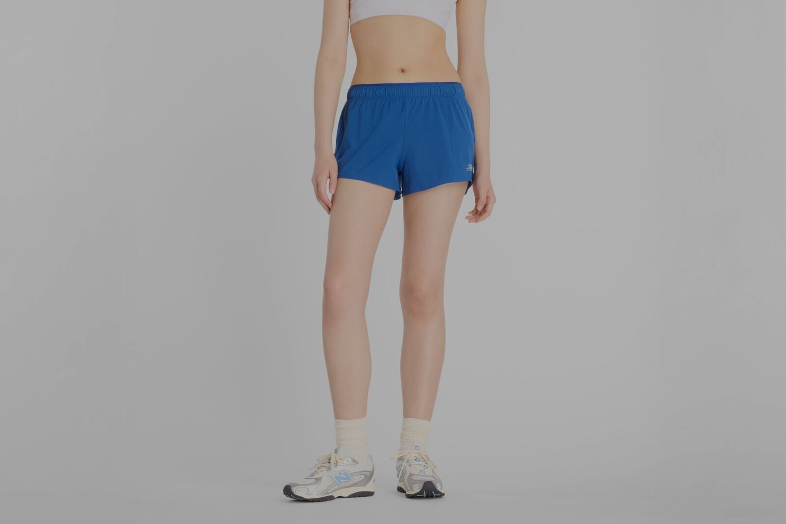 Person wearing blue New Balance shorts.