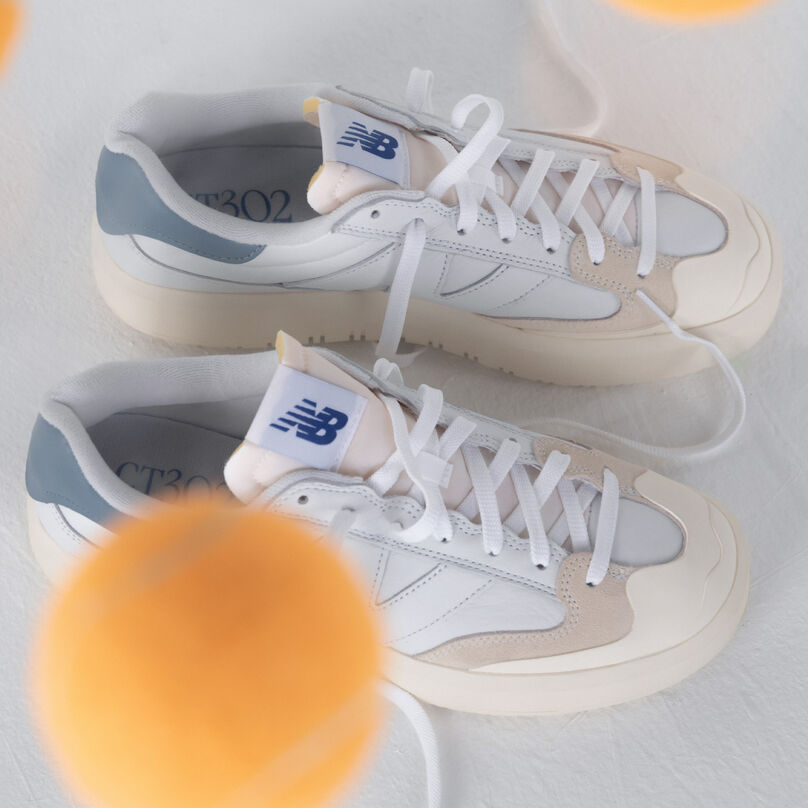 Image détaillée d'une paire de chaussures CT302 blanches avec des balles de tennis