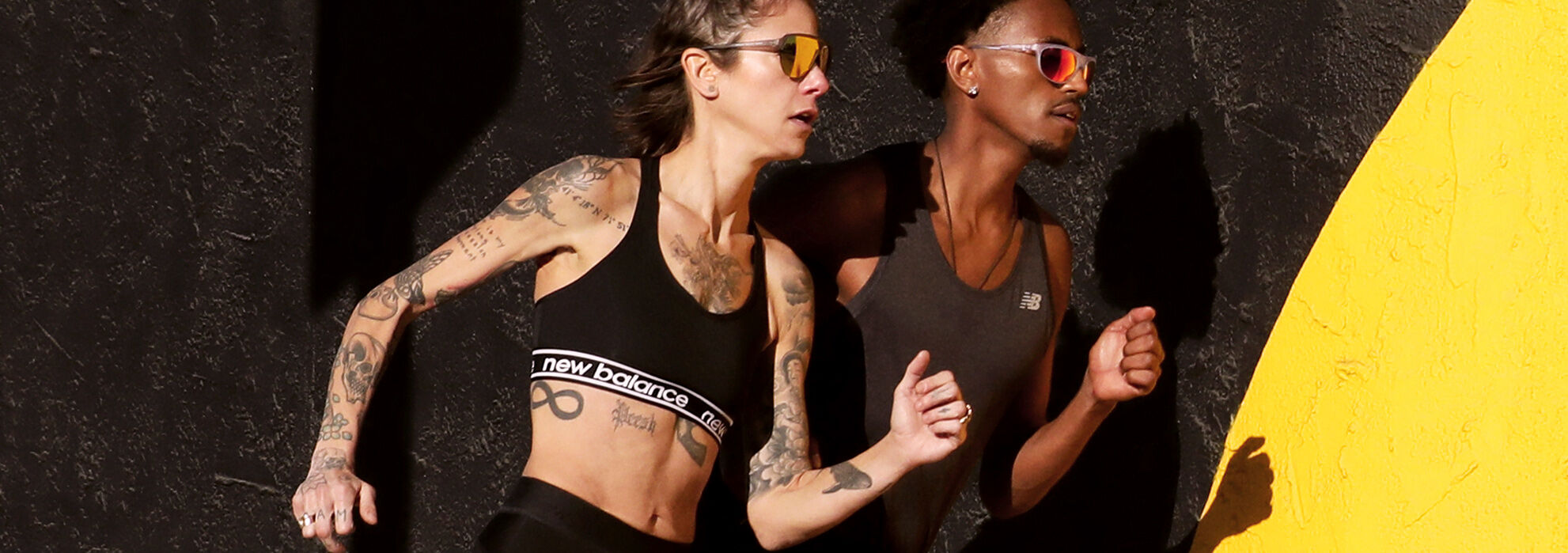 Side profile of two runners waist up, one female and one male