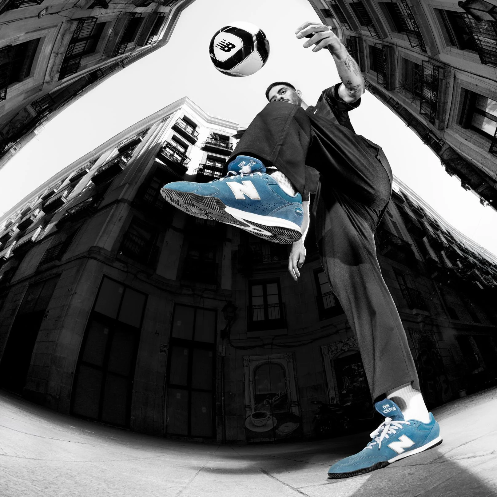 Une personne portant des chaussures Numeric 442, en train de donner un coup de pied dans un ballon de soccer.