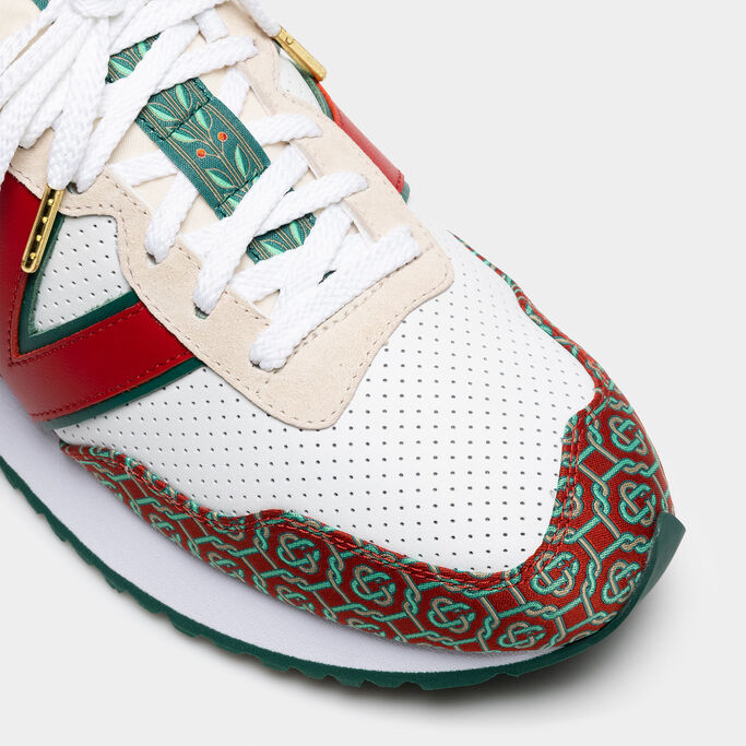 A close-up crop of the toe and tongue of a white, red, and green NB x Casablanca 237 sneaker