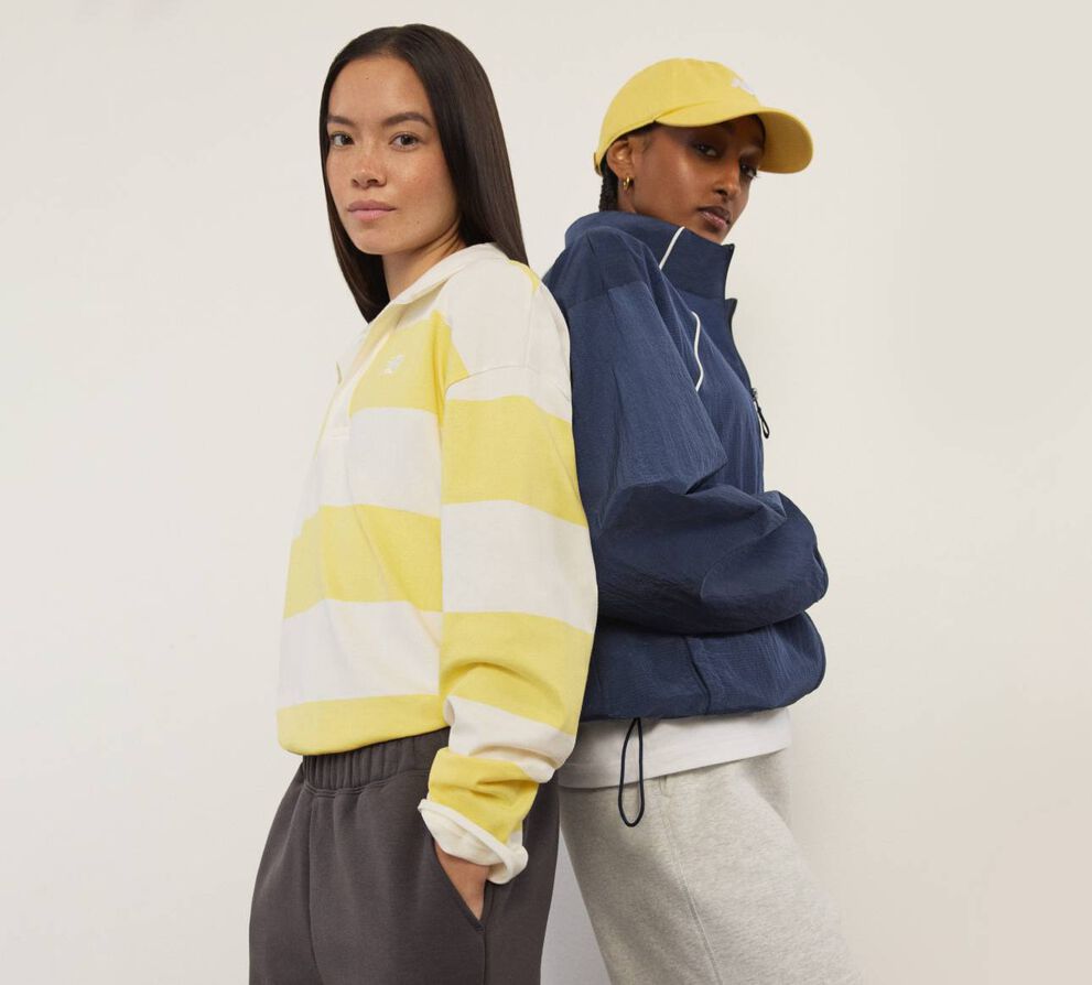 Deux femmes debout dos &agrave; dos, regardant le spectateur.