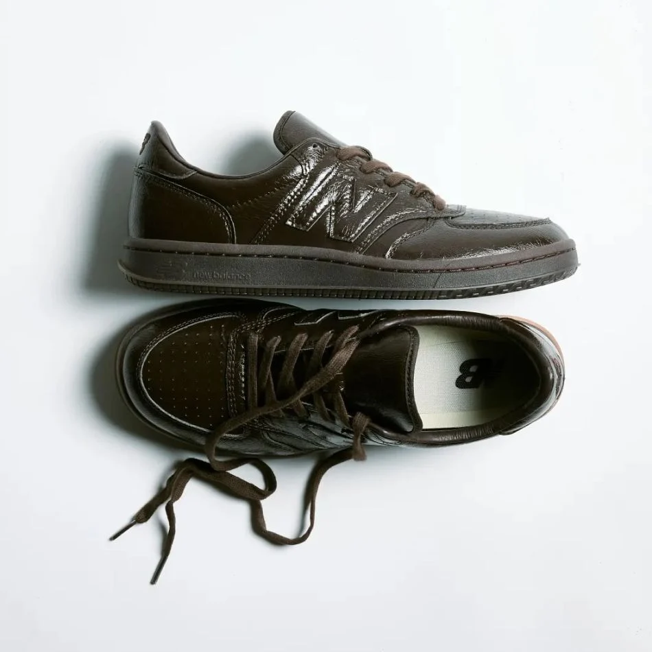 Top-down view of a pair of dark brown New Balance sneakers.