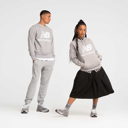 Homme et femme en studio portant des chaussures et des vêtements gris New Balance