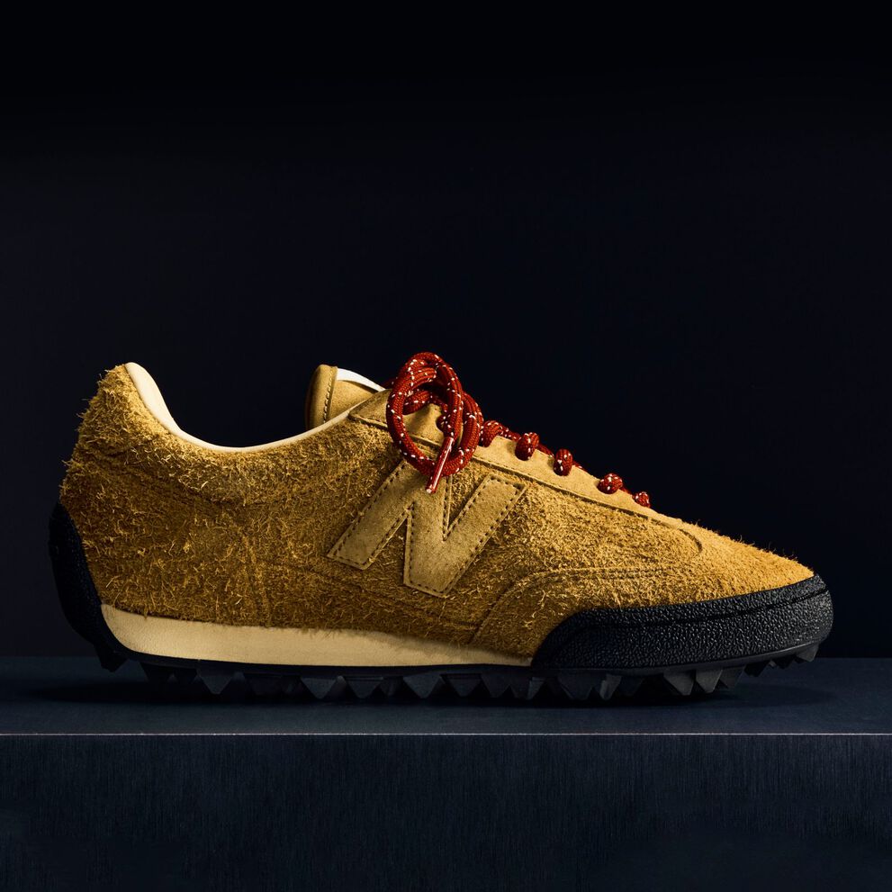 Une chaussure Gator Run en daim rose sur fond noir.