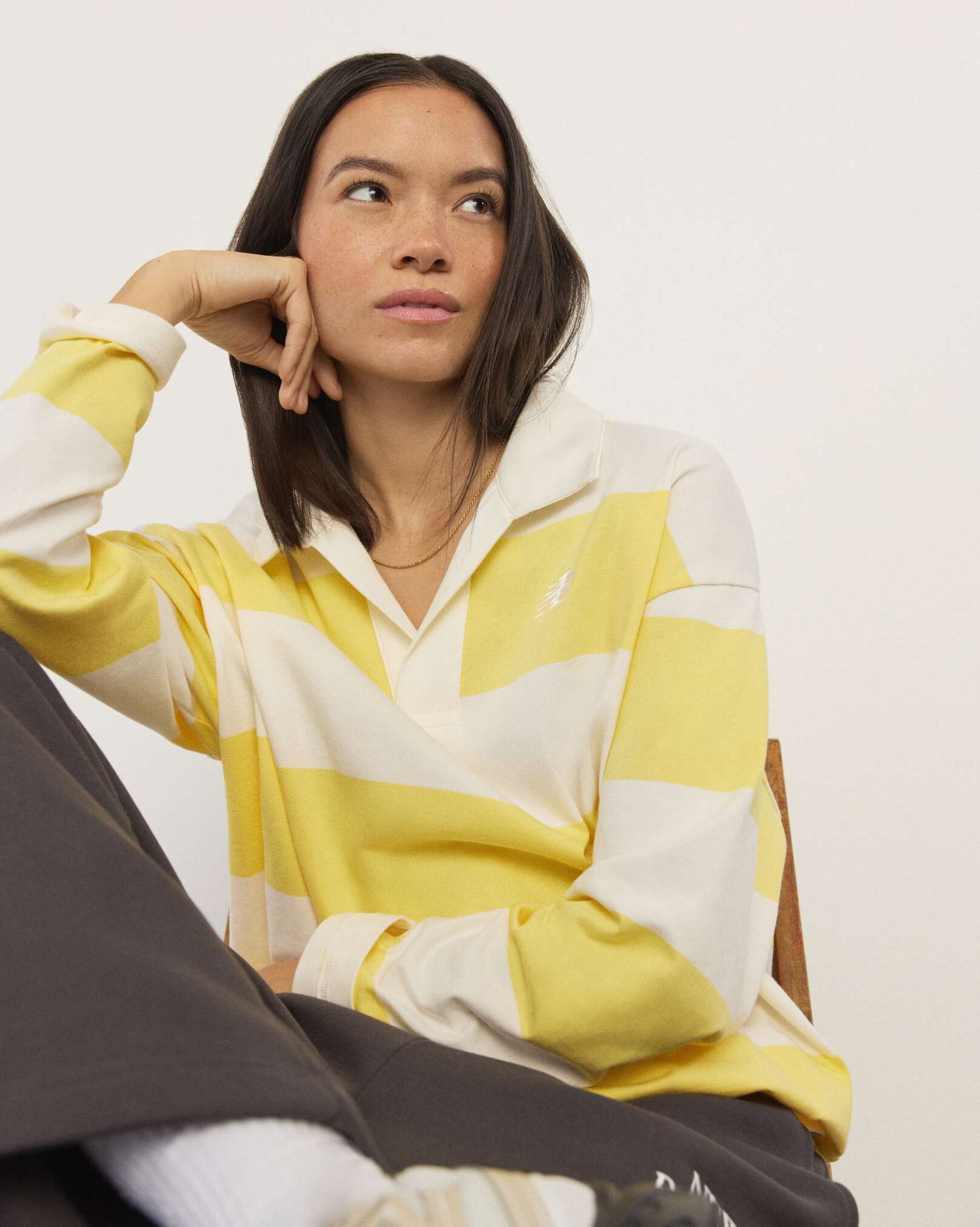 A woman standing in front a white wall.