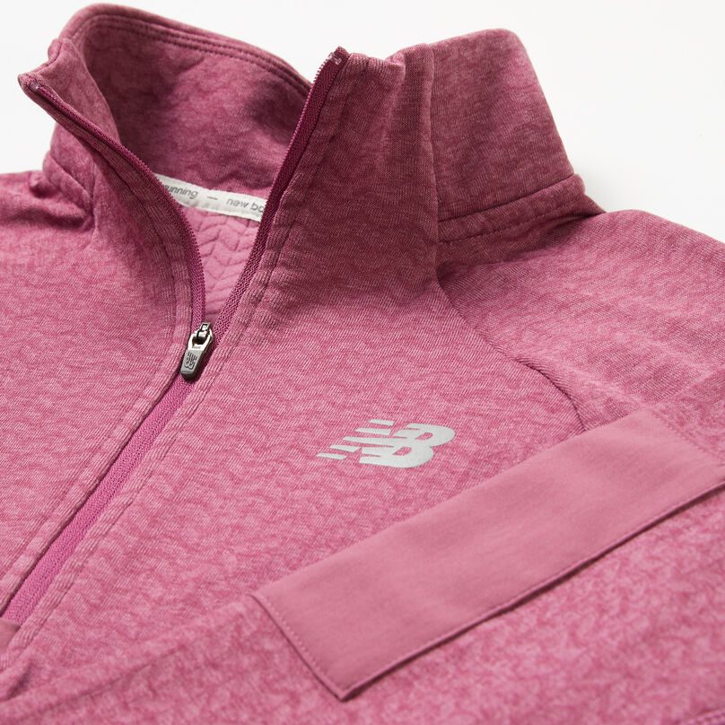Veste rose pour femme posée sur un fond gris mettant en évidence le col.