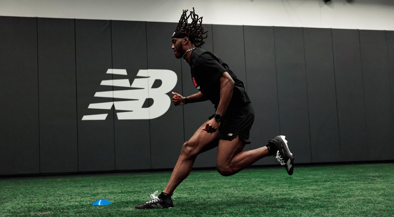 Marvin Harrison Jr. courant sur un terrain en gazon synth&eacute;tique.