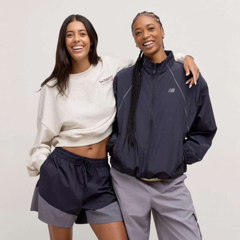 Deux femmes debout ensemble devant un d&eacute;cor de studio cr&egrave;me.