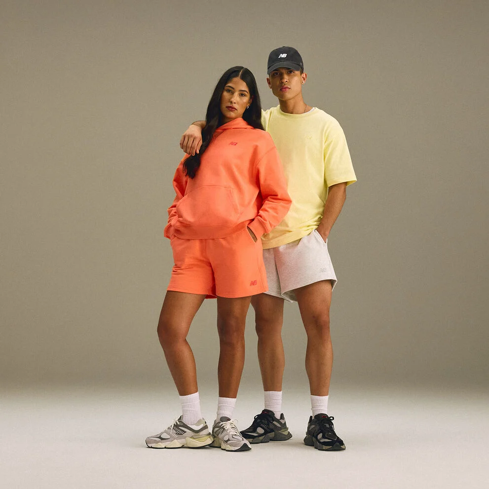 A man and woman standing together in a studio environment. 